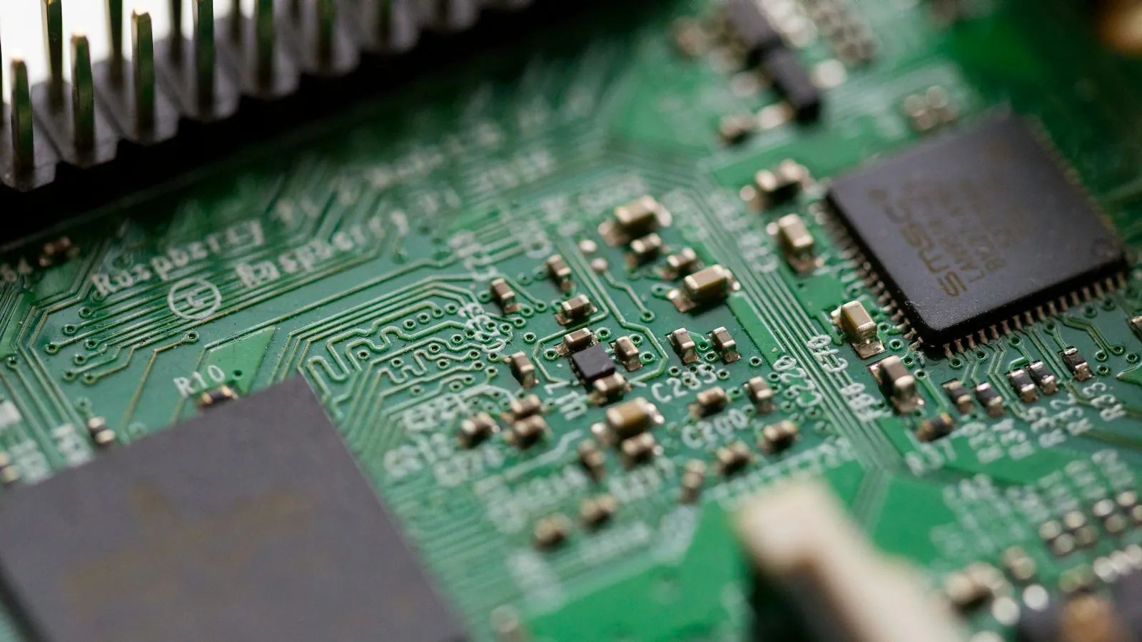 Reparación de una placa electrónica con pinza de precisión.