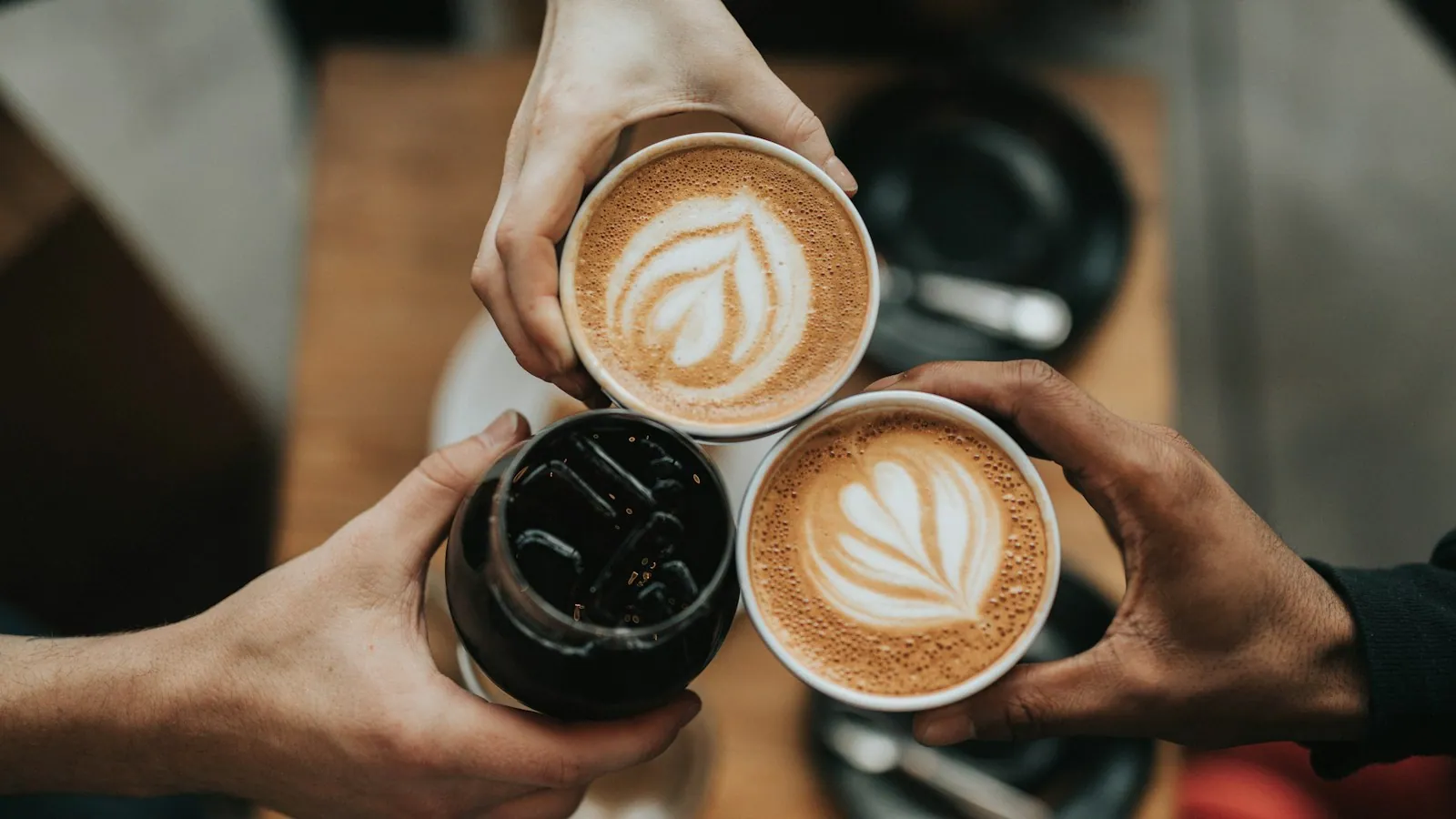 Dos cafés con arte en leche servidos en barra.
